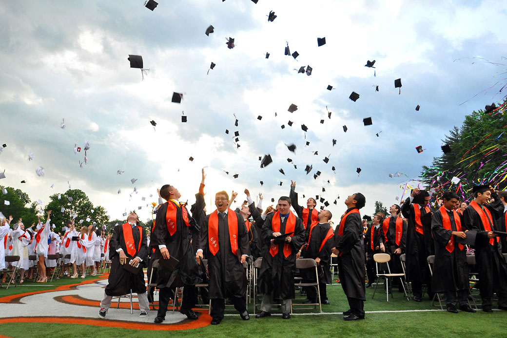 High school graduates throw their caps into the air at the closure of commencement on June 14, 2013. (Getty/Dorann Weber)