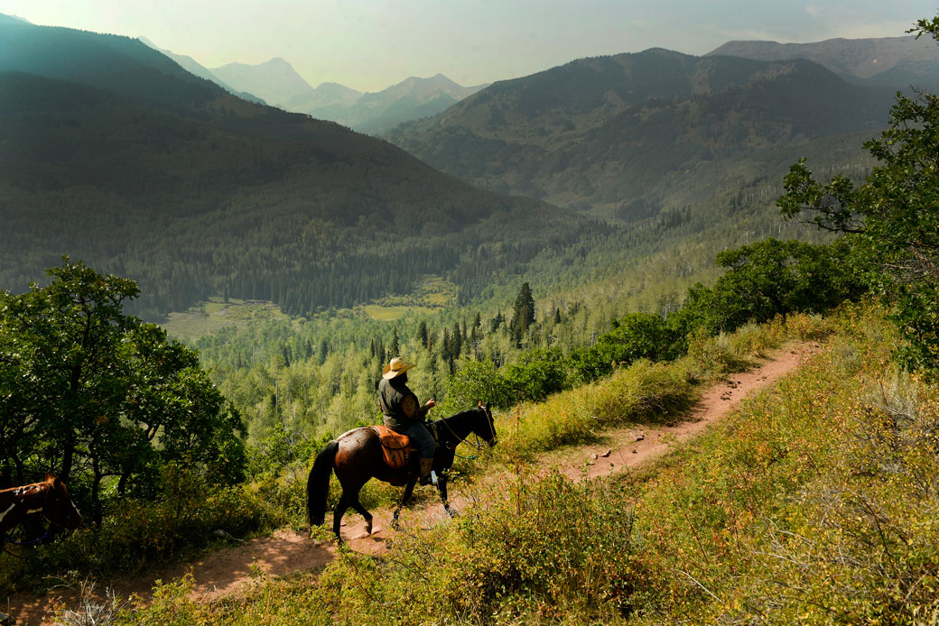 An outfitter rides their horse along Upper Capitol Creek Trail with the massive Capitol Peak in the background on September 6, 2017, in the Maroon Bells-Snowmass Wilderness, Colorado. (Getty/Helen H. Richardson)