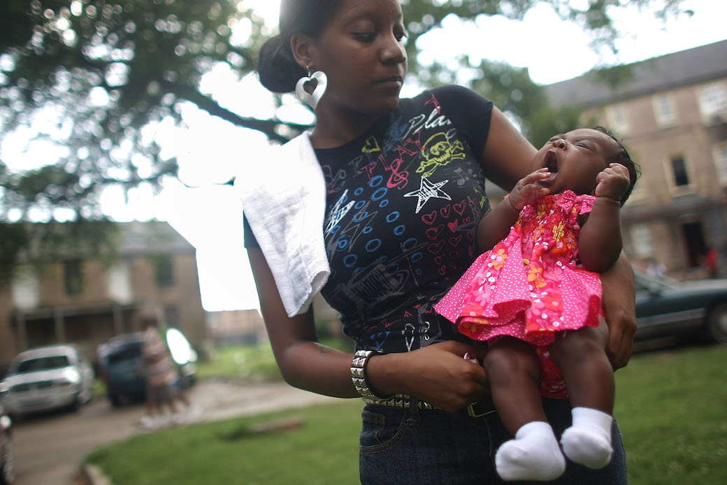 A mother holds her daughter in housing projects in New Orleans, May 2008. (Getty/Mario Tama)
