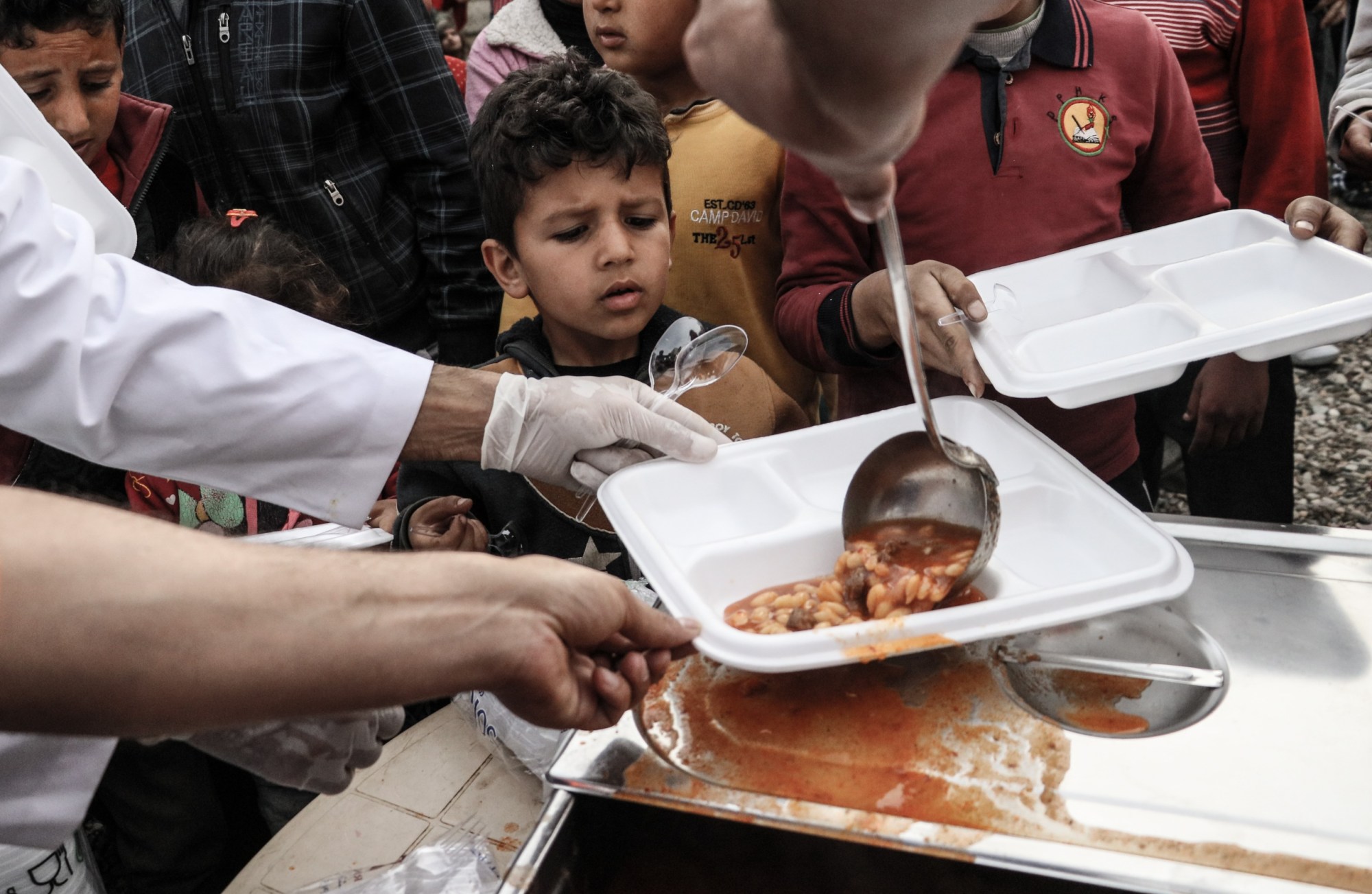 Syrians receive food aid from the Disaster and Emergency Management Presidency in Jinderes, Syria, on March 18, 2018. (Getty/Burak Milli)