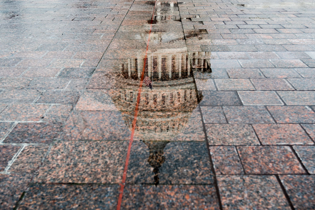 The dome of the U.S. Capitol is reflected in a pool of rainwater, May 2018. (Getty/CQ Roll Call/Bill Clark)