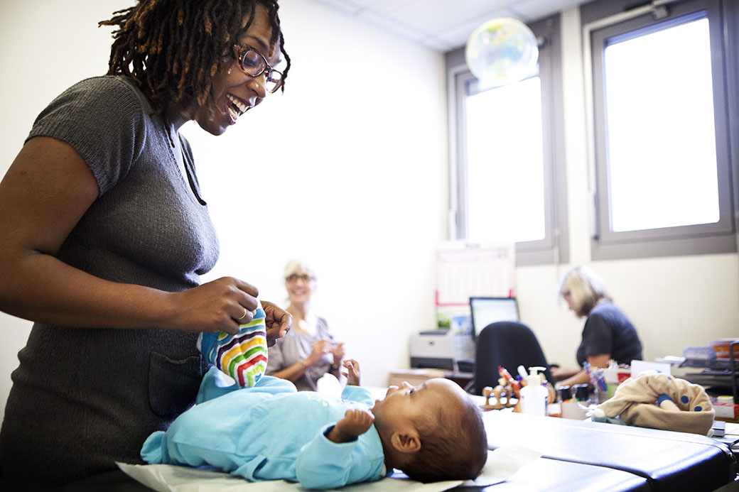 A mother plays with her baby in a postnatal care clinic. (Getty/BSIP/UIG)