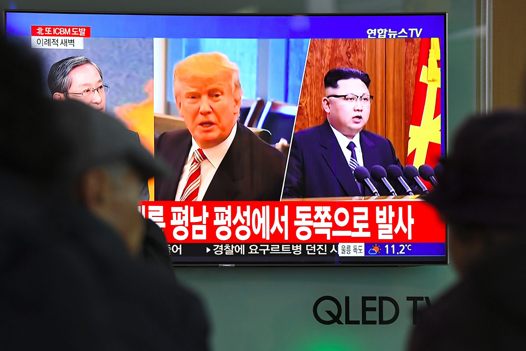 People watch a television news screen showing pictures of U.S. President Donald Trump (center) and North Korean leader Kim Jong Un (right) at a railway station in Seoul, South Korea, November 29, 2017. (Getty/AFP/JUNG Yeon-Je)