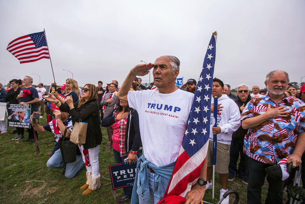 Supporters of President Donald Trump sing the national anthem as they rally for the president during his visit to see the controversial border wall prototypes on March 13, 2018, in San Diego, California. (Getty/David McNew)