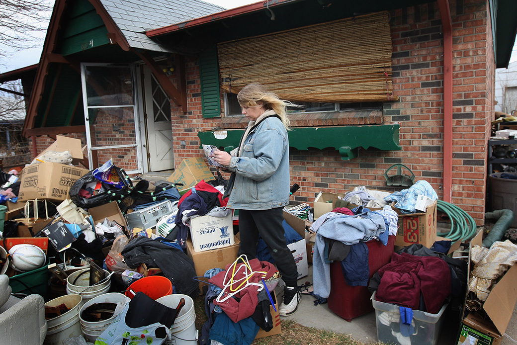 A woman looks over an album of family photos after an eviction team removed all her possessions from her foreclosed home in Colorado, February 2009. (Getty/John Moore)