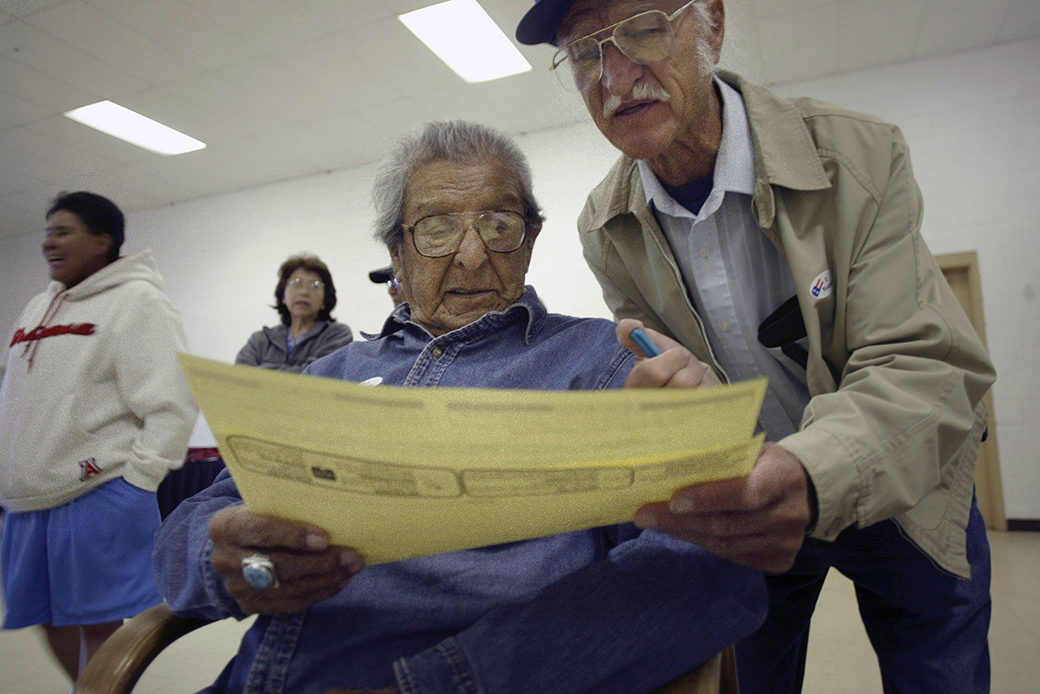 A member of the Pueblo of Acoma reviews a sample ballot with the help of his nephew before casting his ballot in Acoma, New Mexico. (Getty/Stringer/Rick Scibelli)