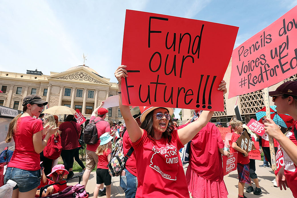 An Arizona teacher holds up a sign in front of the state capitol during a rally on April 26, 2018. in Phoenix. (Getty/Ralph Freso)