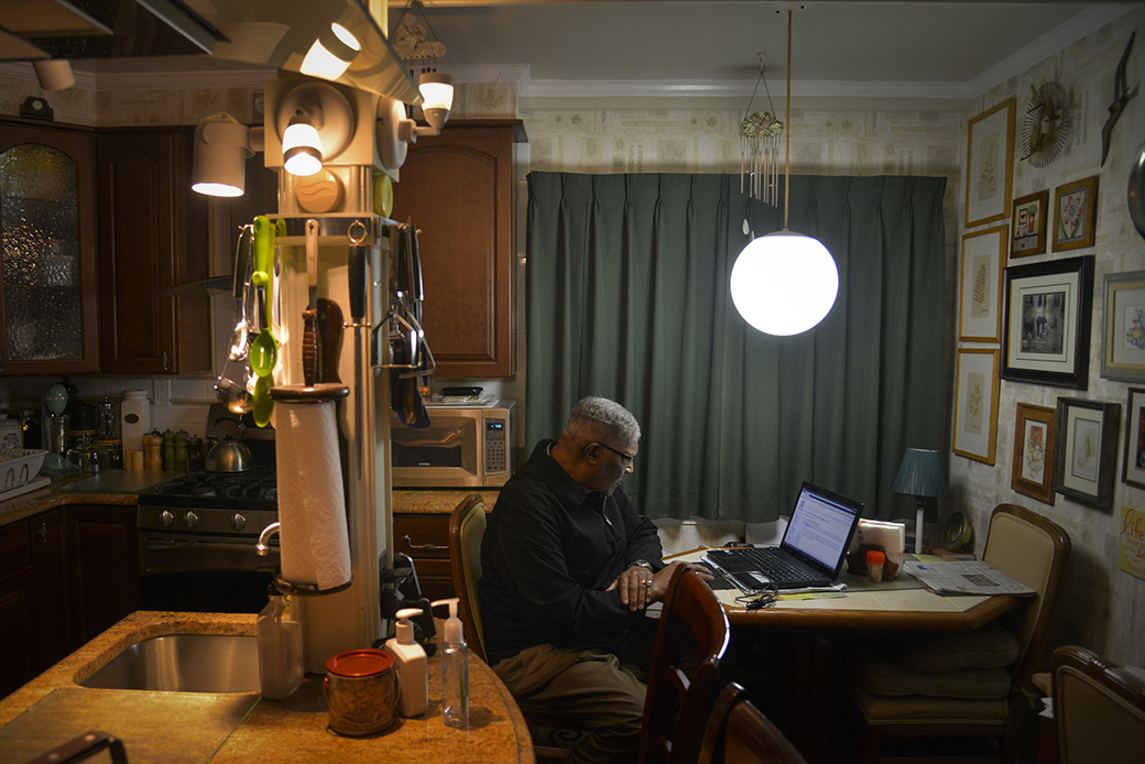 A man reads the news online in his kitchen, May 2014, in Mitchellville, Maryland. (Getty/The Washington Post/Jahi Chikwendiu)