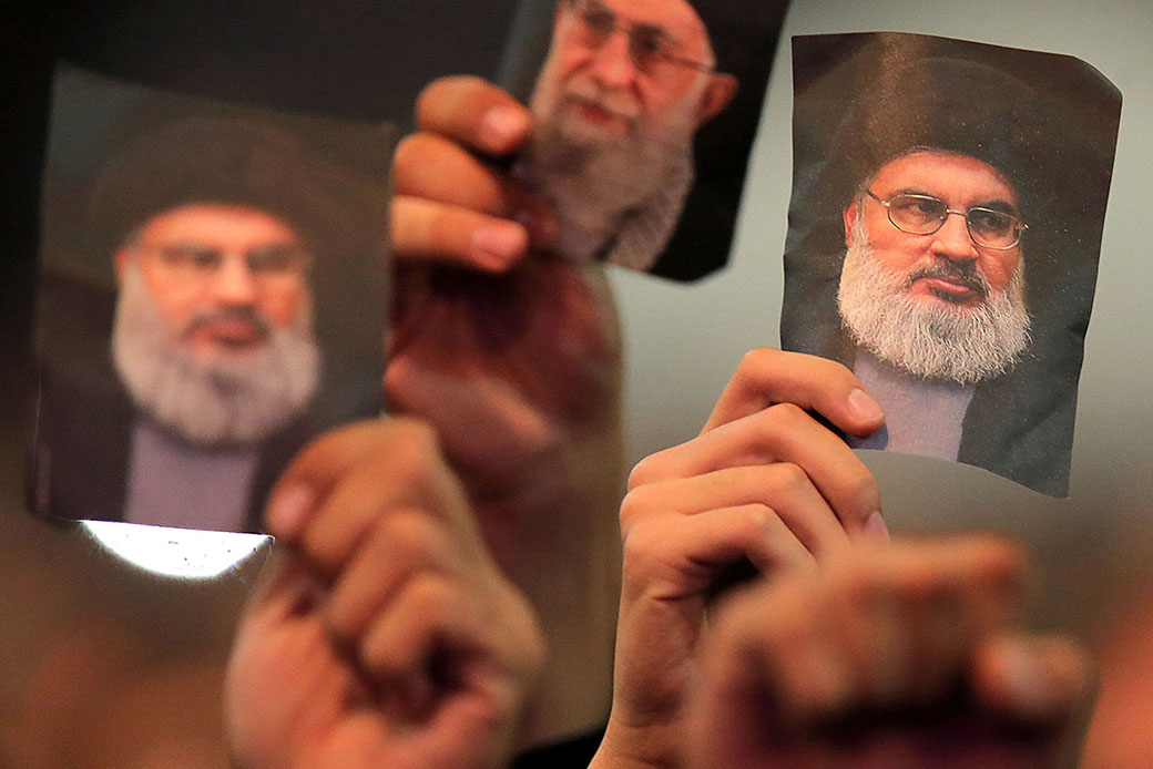 Supporters of Lebanon's Shiite militia Hezbollah carry portraits of Iran's supreme leader, Ayatollah Seyed Ali Khamenei, and Hezbollah's secretary-general, Hassan Nasrallah, during a ceremony on the eve of the 10th day of the mourning period of Muharram, which marks the day of Ashura, in a southern suburb of the capital Beirut, October 11, 2016. (Getty)