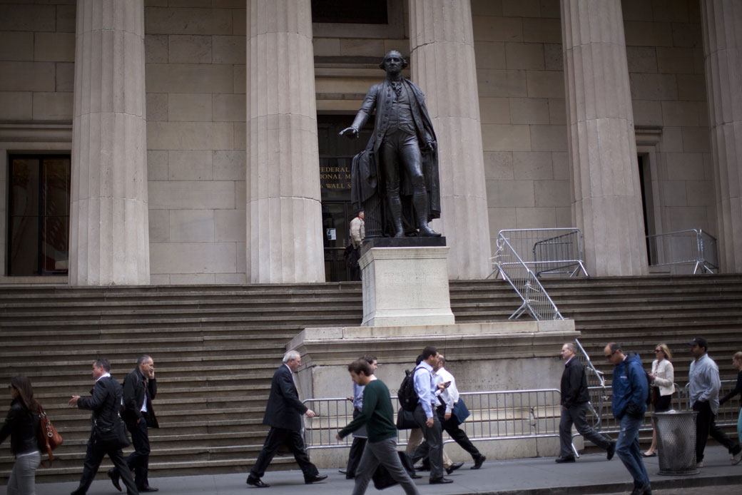 People walk past Federal Hall on Wall Street, New York City, June 2012. (Getty/Robert Nickelsberg)