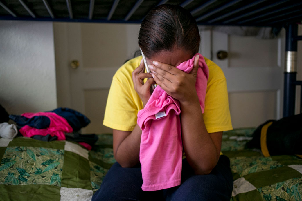 An immigrant woman speaks on the phone with her mother in El Salvador, with whom she had not spoken since leaving the country, San Antonio, Texas, July 2016. (Getty/The Washington Post/Ilana Panich-Linsman)