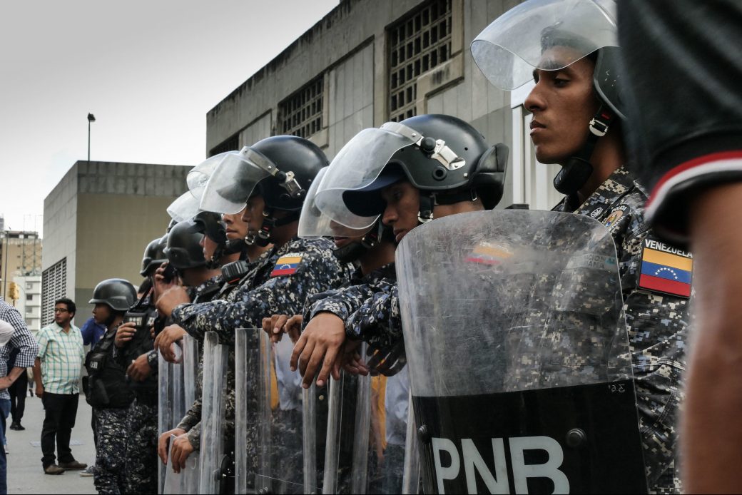 Protesters gather outside of the headquarters of the Bolivarian National Intelligence Service in Caracas, where they are met with a heavy police presence. (Getty/Roman Camacho)