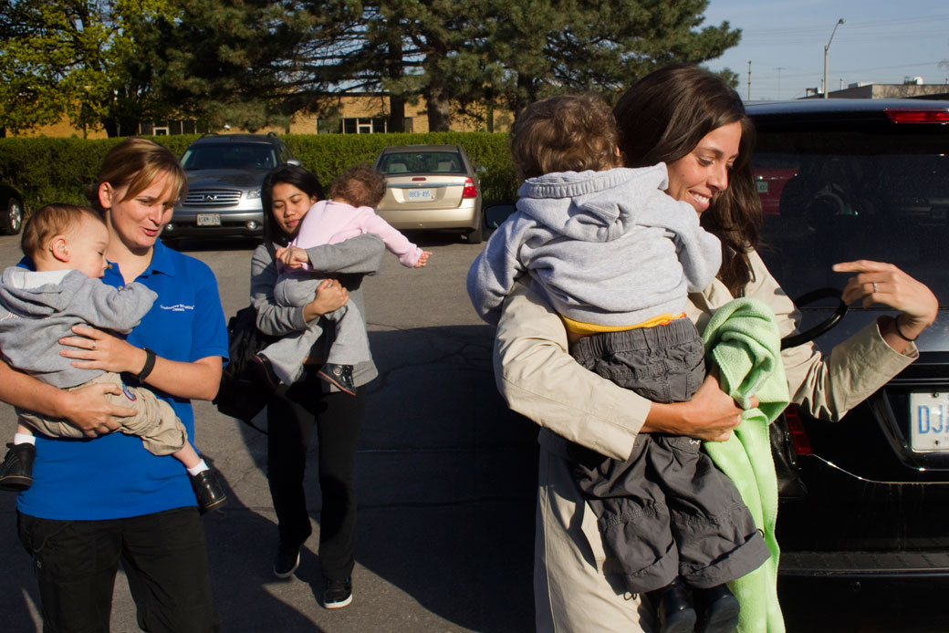 A mother and two caregivers carry children to a conductive education therapy session. (Getty/Andrew Francis Wallace)