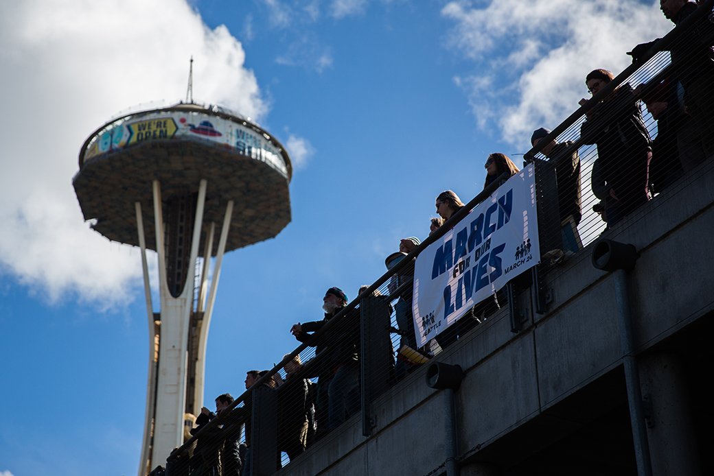 Spectators get a better view of the crowd from Fisher Pavilion, the Space Needle in the background, during the March for Our Lives rally on March 24, 2018, in Seattle, Washington. (Getty/Lindsey Wasson)