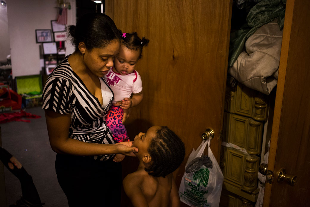 A woman talks to her son while holding her infant daughter at their Flint, Michigan, home, February 2016. (Getty/The Washington Post/Brittany Greeson)