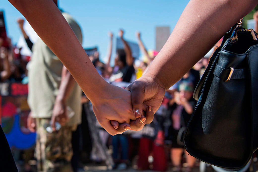 Two women hold hands as demonstrators protest Supreme Court nominee Brett Kavanaugh near the U.S. Capitol on October 4, 2018, in Washington, D.C. (Getty/AFP/Jim Watson)