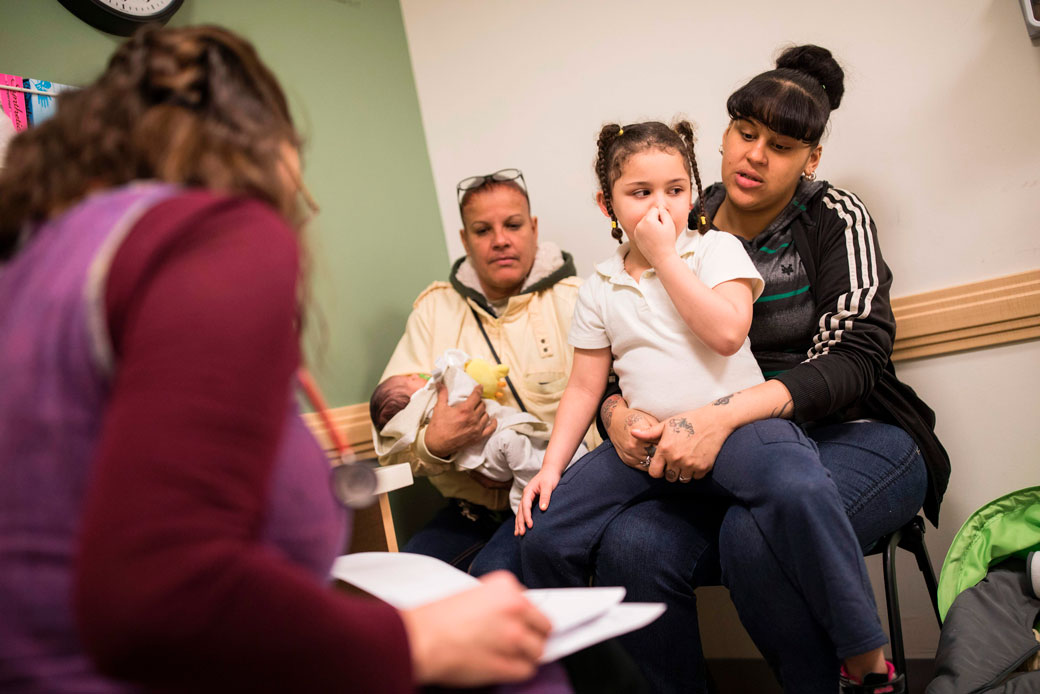 A mother visits the pediatrician with her two children and mother in Philadelphia, Pennsylvania. (Getty/AFP/Dominick Reuter)
