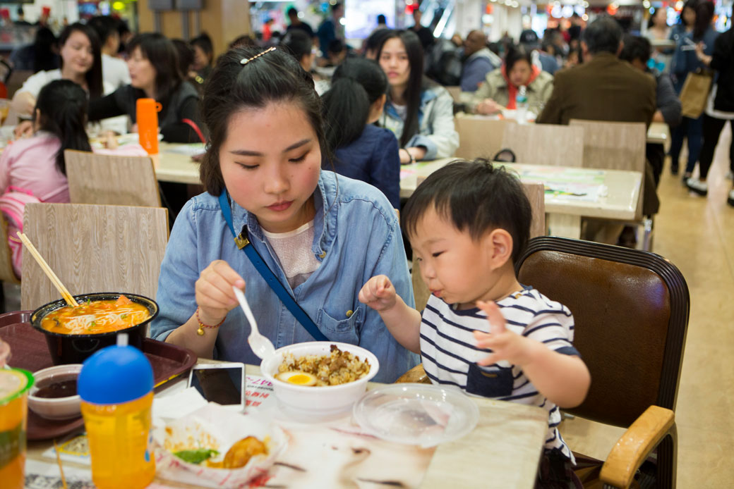 A mother eats with her son at a food court, April 2017. (Getty/The Christian Science Monitor/Melanie Stetson Freeman)