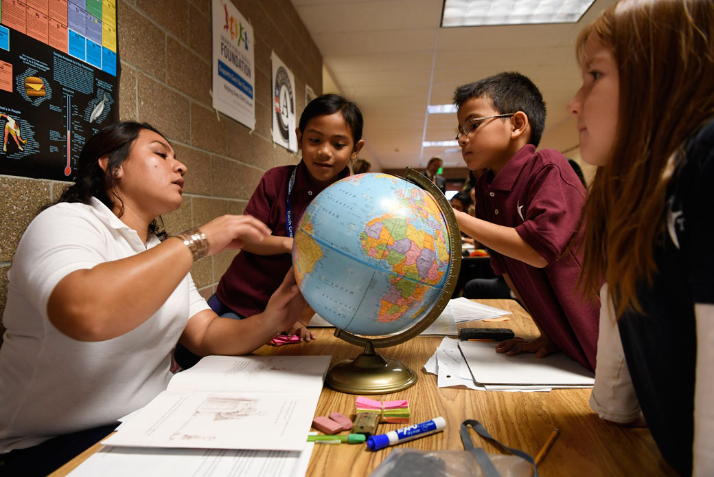 A parent tutor teaches geography to students at Greenwood Academy during Denver Public Schools' Each One Teach One program, November 2016.