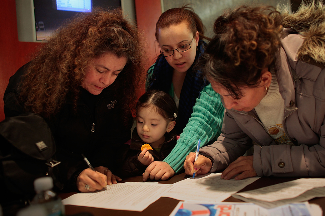A school administrator helps translate school admissions lottery forms for Spanish-speaking parents in the Brooklyn borough of New York City, April 2009. (Getty/Chris Hondros)