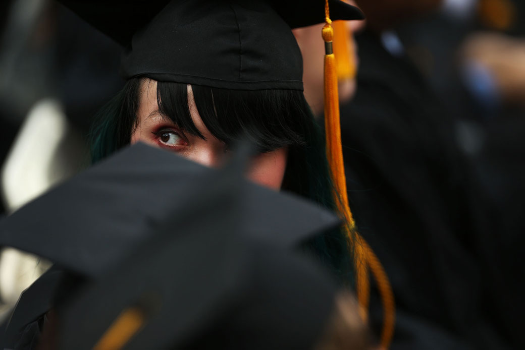 A student watches the commencement address during graduation ceremonies at the City College of New York on June 3, 2016. (Getty/Spencer Platt)
