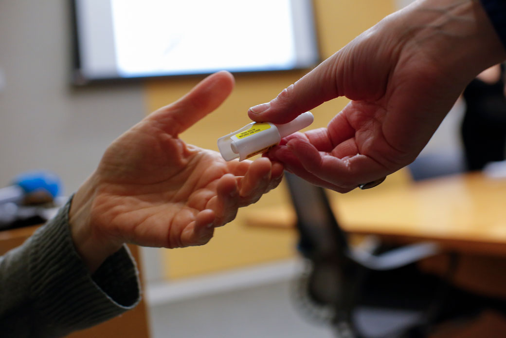 A man holds a nasal spray that is used to treat opioid overdose at a Narcan training session in Queens, New York, March 2018.