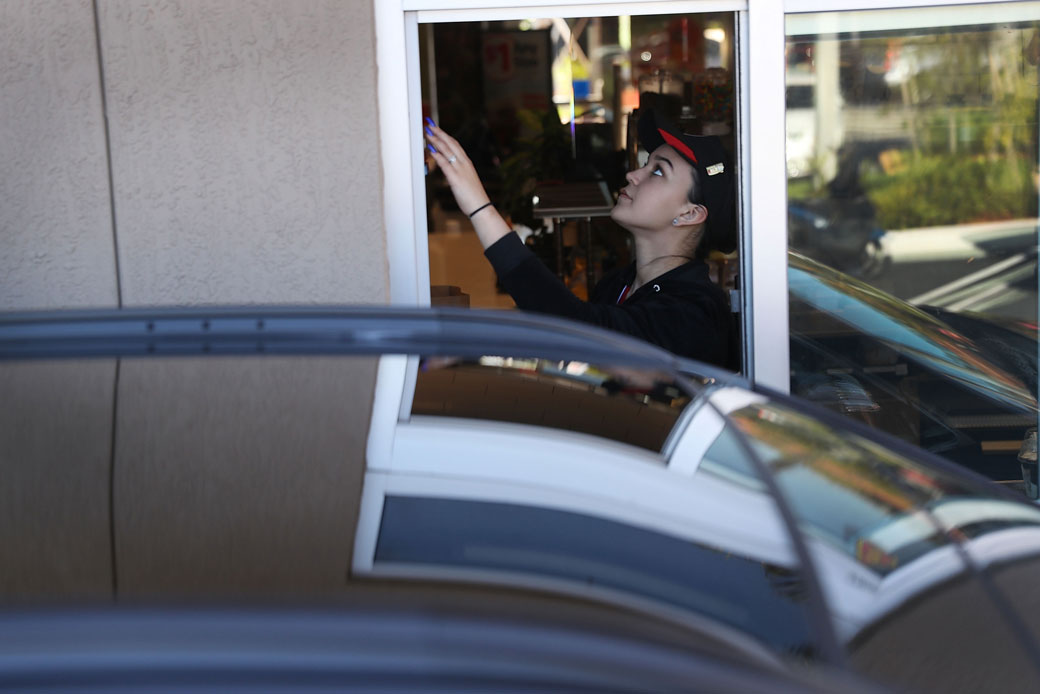A McDonald's employee works the drive-thru window at a restaurant in Miami on April 25, 2017. (Getty/Joe Raedle)