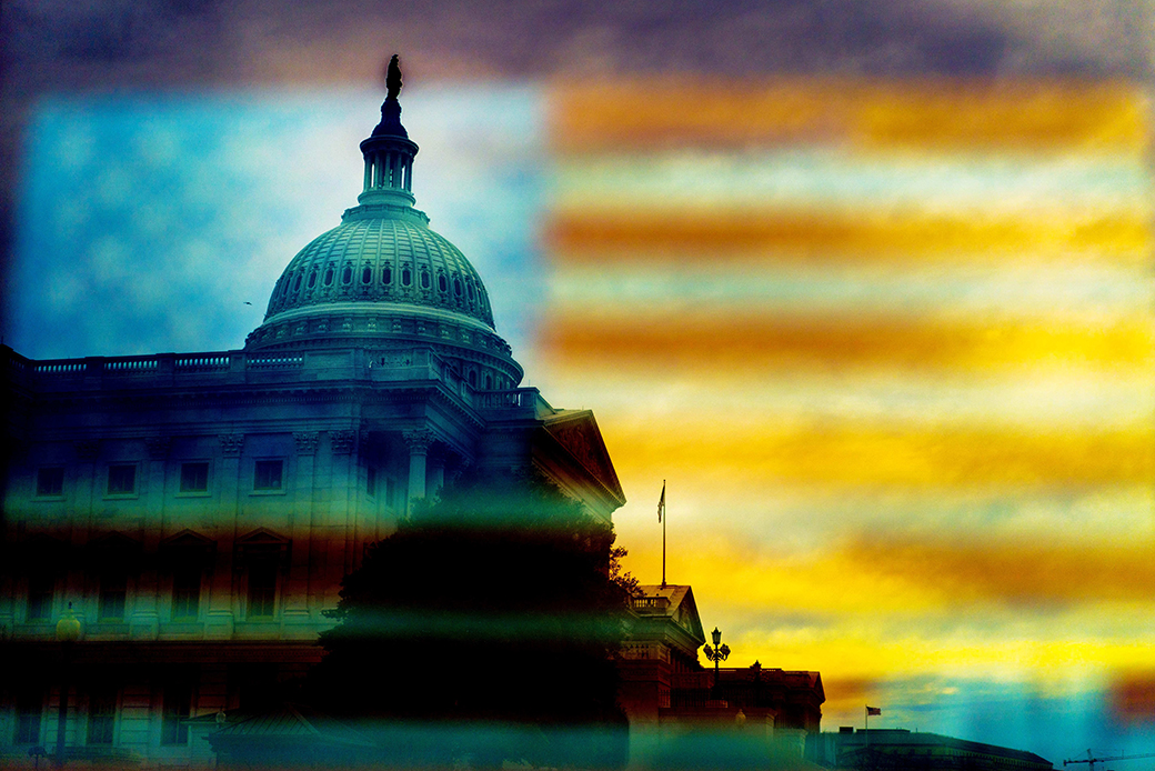 The dome of the U.S. Capitol is viewed through a reflection of the American flag on Capitol Hill in Washington, January 1, 2019. (Getty/Melina Mara)