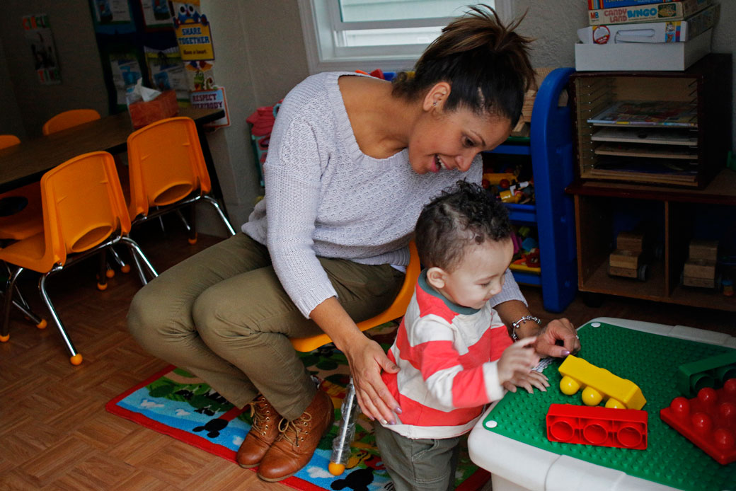 A mother plays with her 1-year-old son at a day care center in Lynn, Massachusetts, March 2015.