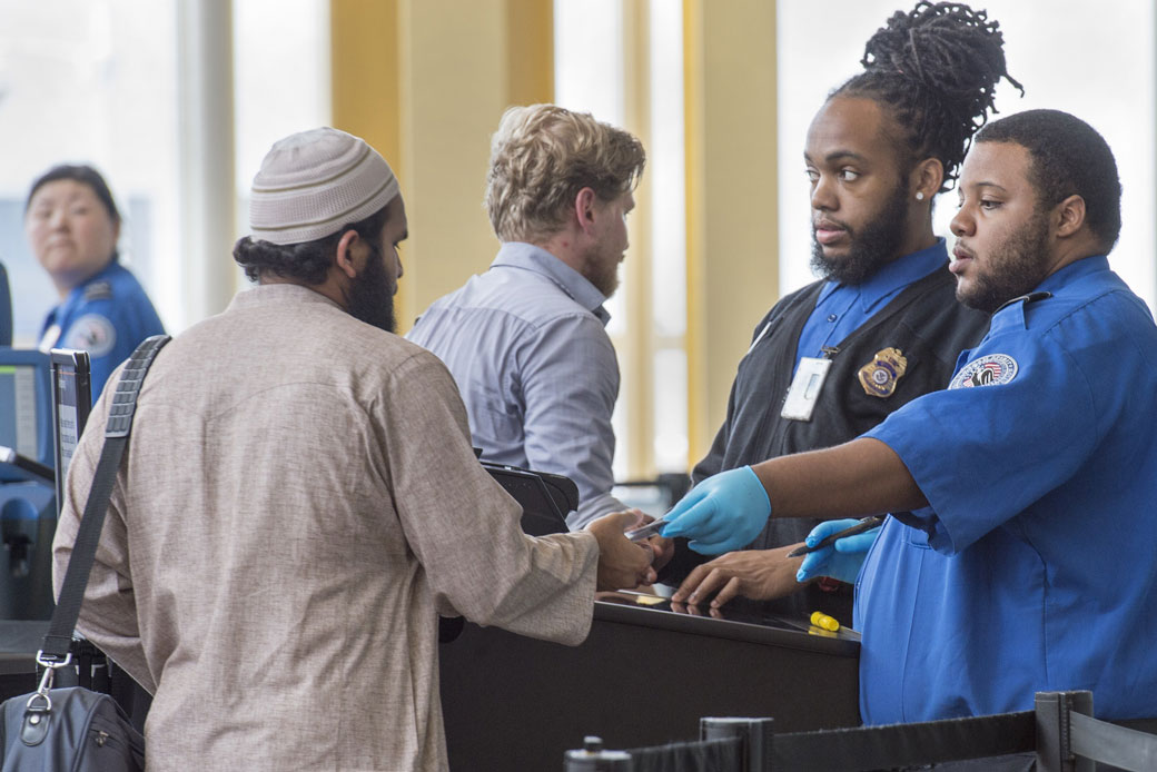 Transportation Security Administration officers inspect an airline passenger's travel documents in Washington, D.C., June 2015. (Getty/Paul J. Richards/AFP)