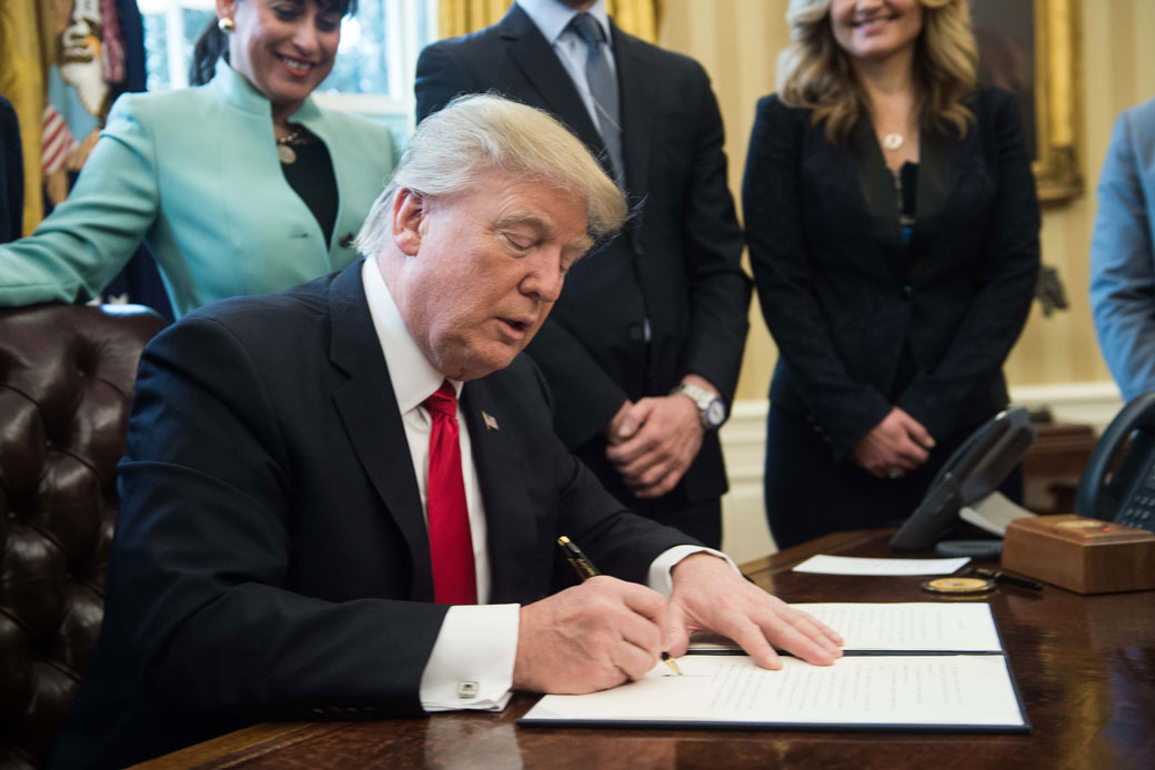 President Donald Trump signs an executive order in the Oval Office at the White House in Washington, D.C., January 2017. (Getty/Nicholas Kamm/AFP)
