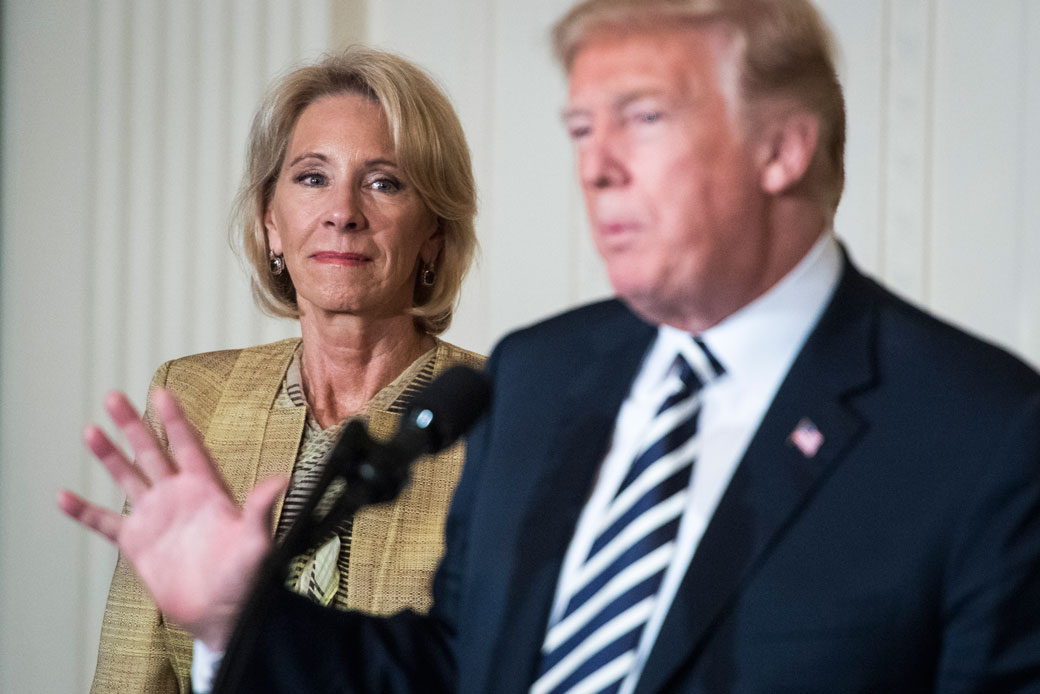 Secretary of Education Betsy DeVos listens as President Donald J. Trump speaks, May 2018. (Getty/Jabin Botsford)