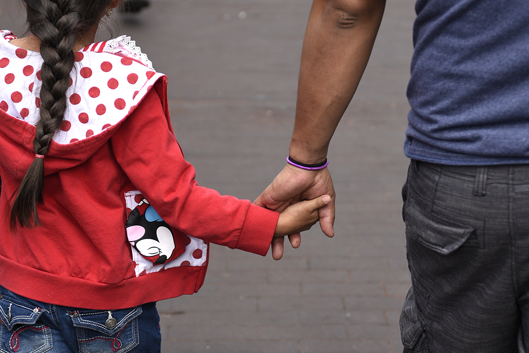 A father walks hand in hand with his daughter as they enjoy a Fourth of July holiday event in Santa Fe, New Mexico. (Getty/Robert Alexander)