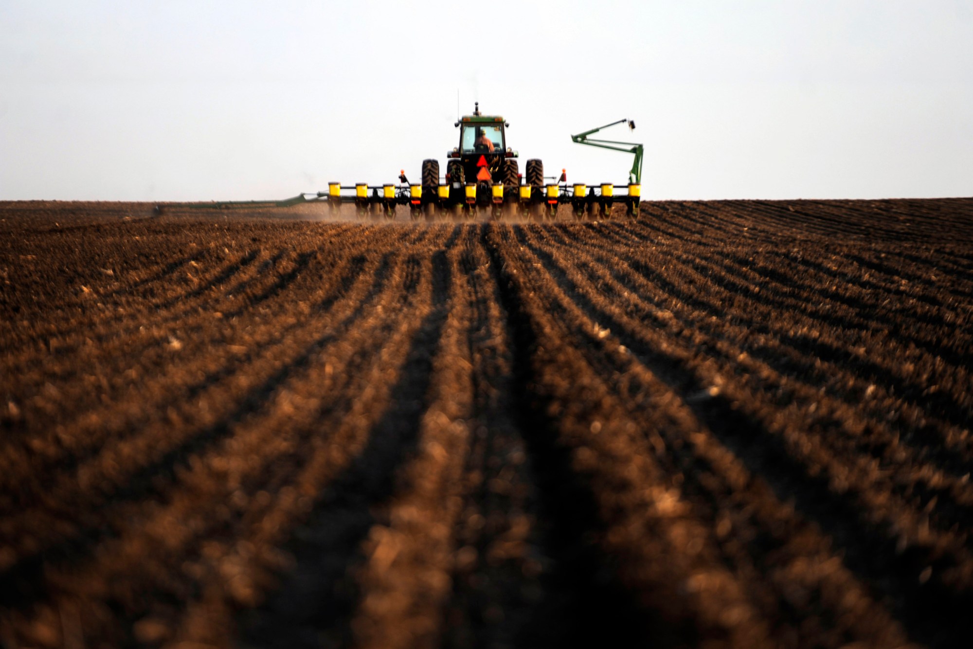 A crop farmer and recipient of USDA farm subsidies works to prepare equipment for evening planting of corn in Hull, Sioux County, Iowa, April 2011. (Getty/Melina Mara)