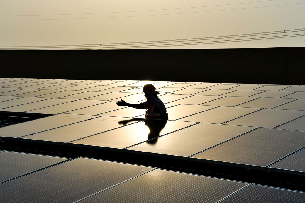 An Indian laborer installs solar panels at a site in Greater Noida, some 30 miles east of the capital New Delhi, May 2017. (Getty/AFP/Chandan Khanna)