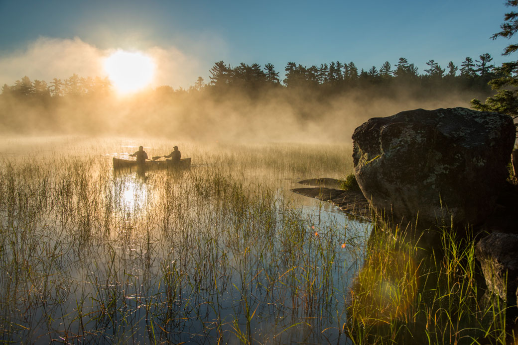Two canoers paddle through mist in Minnesota's Boundary Waters Canoe Area Wilderness. (Getty/Layne Kennedy)