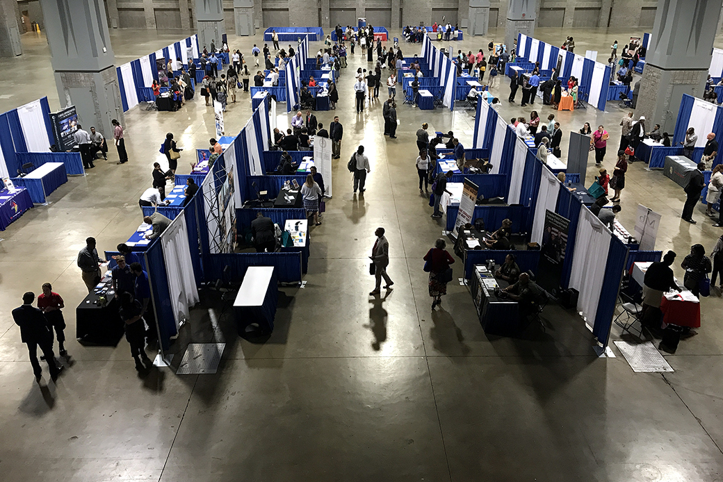 Job seekers mill about employers' booths at a job fair in Washington, D.C., August 2017. (Getty/Jessica Contrera)