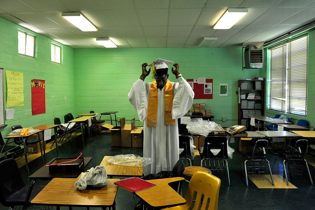 A high school student in Ruleville, Mississippi, adjusts his cap in preparation for his graduation ceremony, May 2015. (Getty/The Washington Post/Michael S. Williamson)