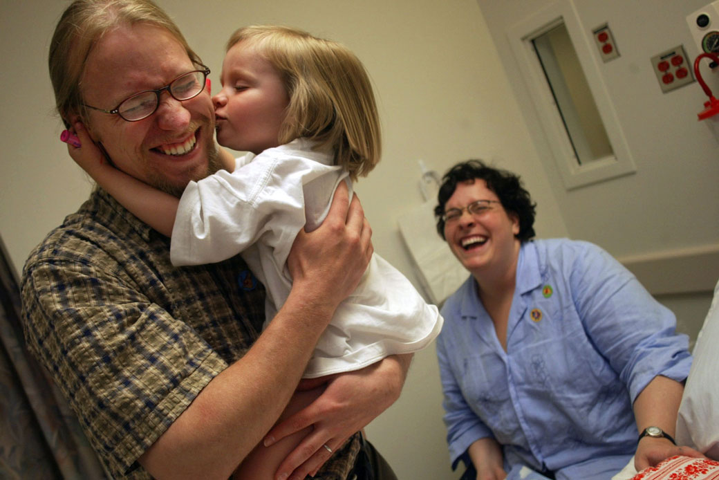 A 3-year-old girl gives her father a kiss as she waits to undergo surgery at a children's hospital in St. Paul, Minnesota.