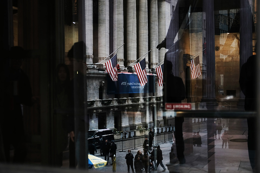 People walk by the New York Stock Exchange as Federal Reserve Board Chairman Jerome Powell holds a news conference, December 19, 2018, in New York City. (Getty/Spencer Platt)