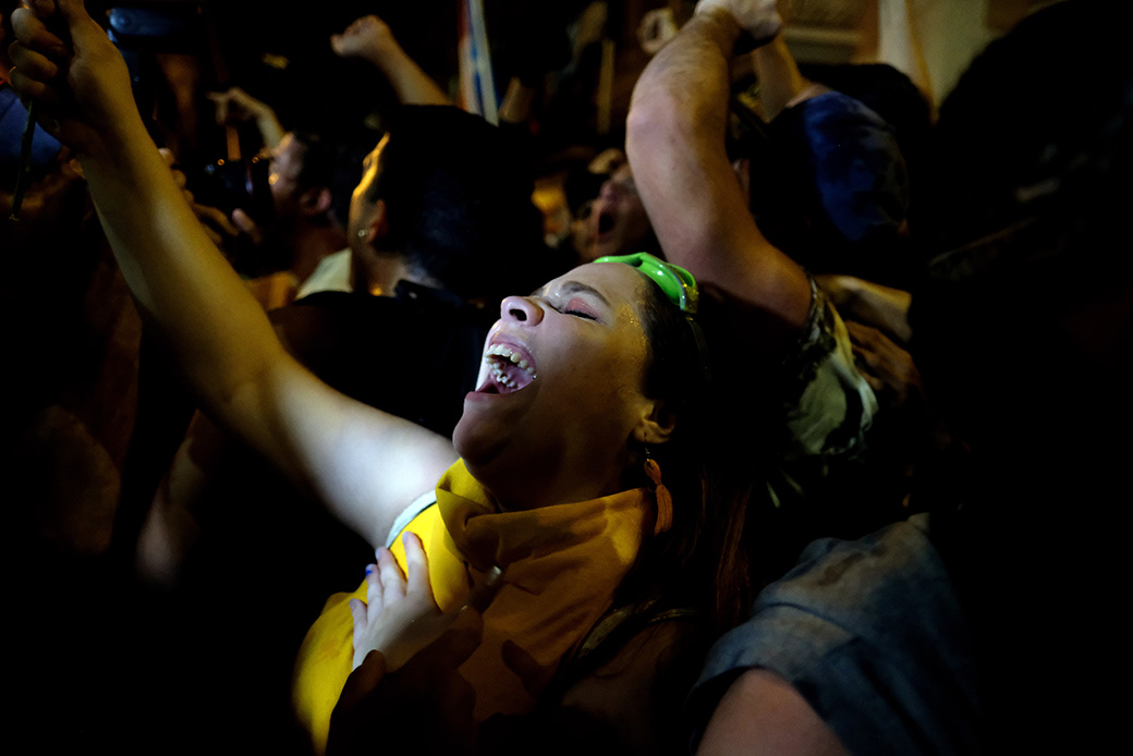 Demonstrators celebrate in front of the Puerto Rican governor's mansion after his resignation message, in San Juan, July 24, 2019. (Getty/Ricardo Arduengo)