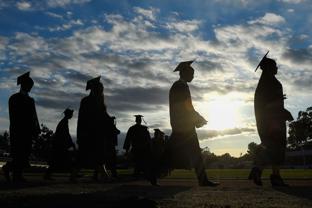  (Students in California attend their outdoor high school graduation ceremony.)