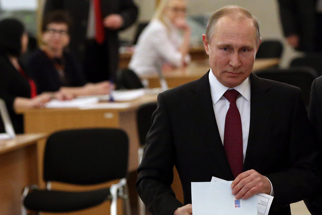  (Russian President Vladimir Putin holds a ballot to vote at a polling station in Moscow, March 2018.)