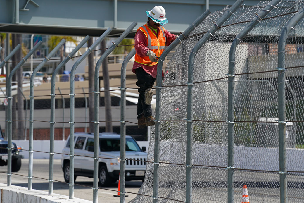 A worker takes down a chain-link fence in Long Beach, California, April 2019. (Getty/Scott Varley)
