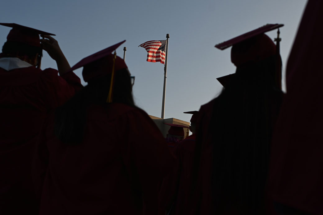 A U.S. flag flies above a building as students participate in a graduation ceremony in Pasadena, California, June 2019. (Getty/Robyn Beck/AFP)