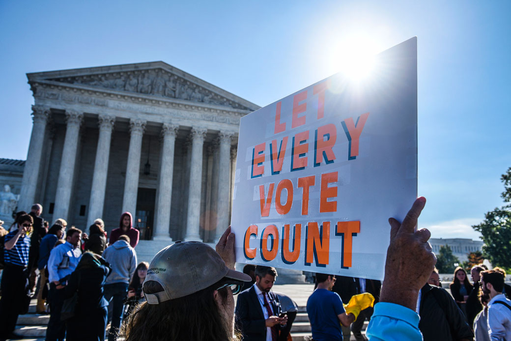 People hold signs during a rally at the U.S. Supreme Court in Washington, D.C., calling for 