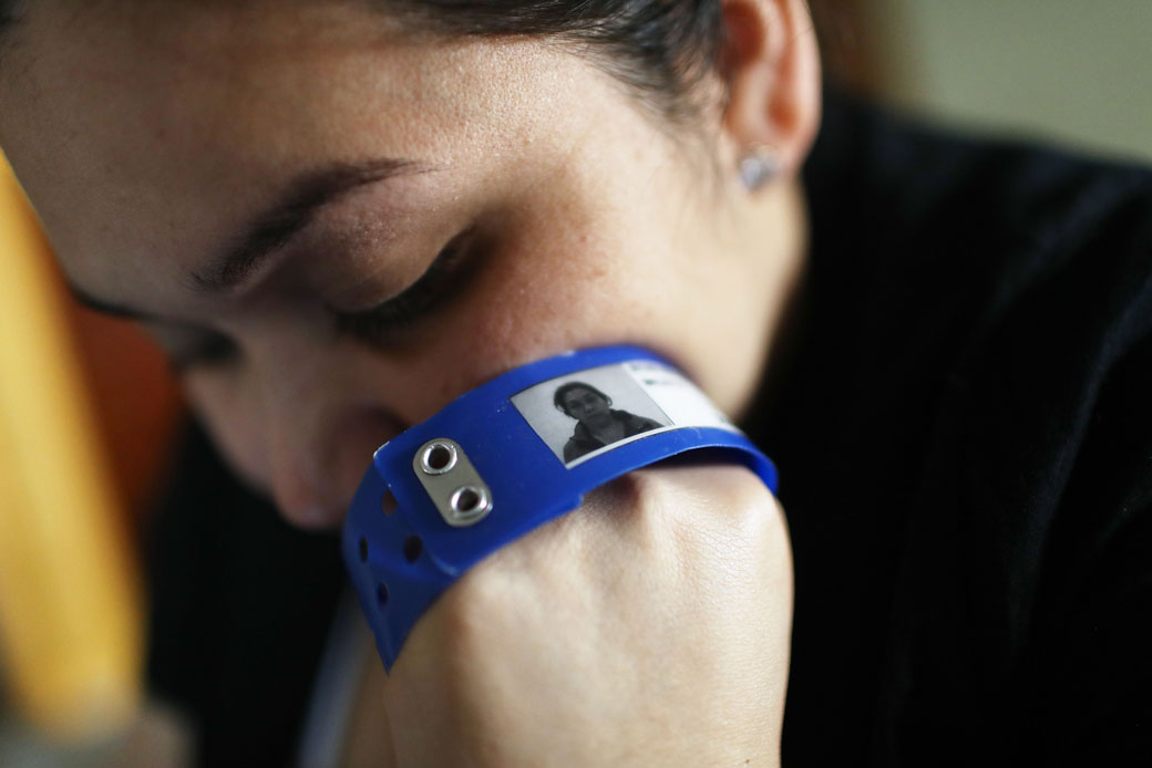 (An immigrant woman, recently released after spending six months in an ICE detention facility, clutches her ICE identification bracelet in her hotel room in Los Angeles, September 2018.)