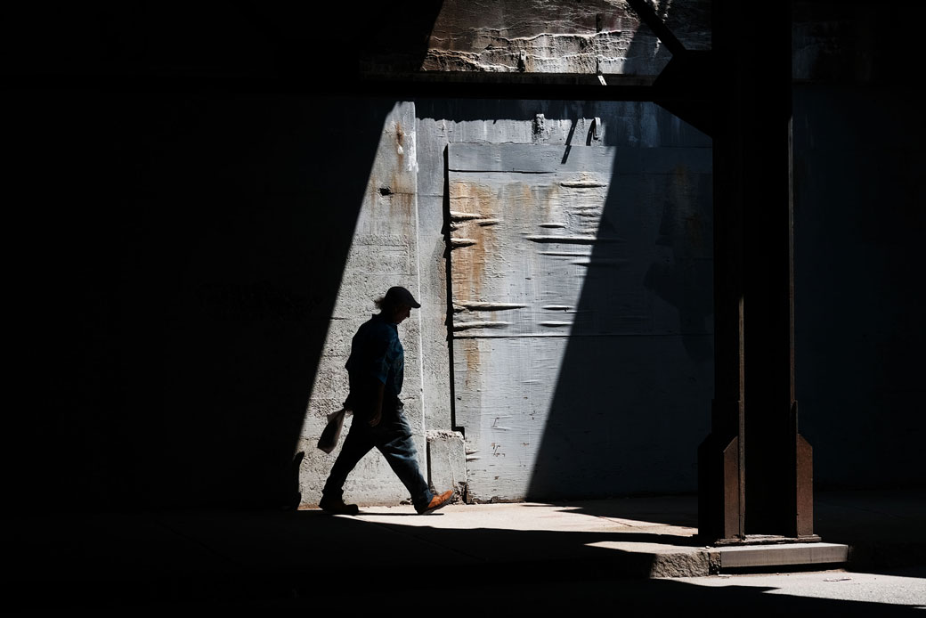 A man walks along a street in Lawrence, Massachusetts, which has struggled to find its economic base since the decline of manufacturing, August 2019. (Getty/Spencer Platt)