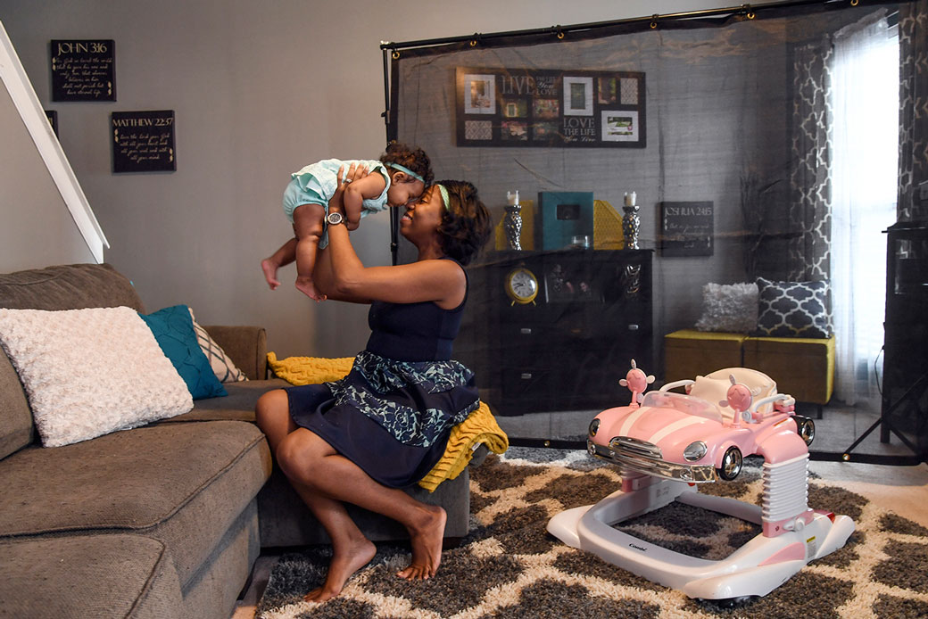  (A woman in North Carolina plays with her baby after work, August 2017.)