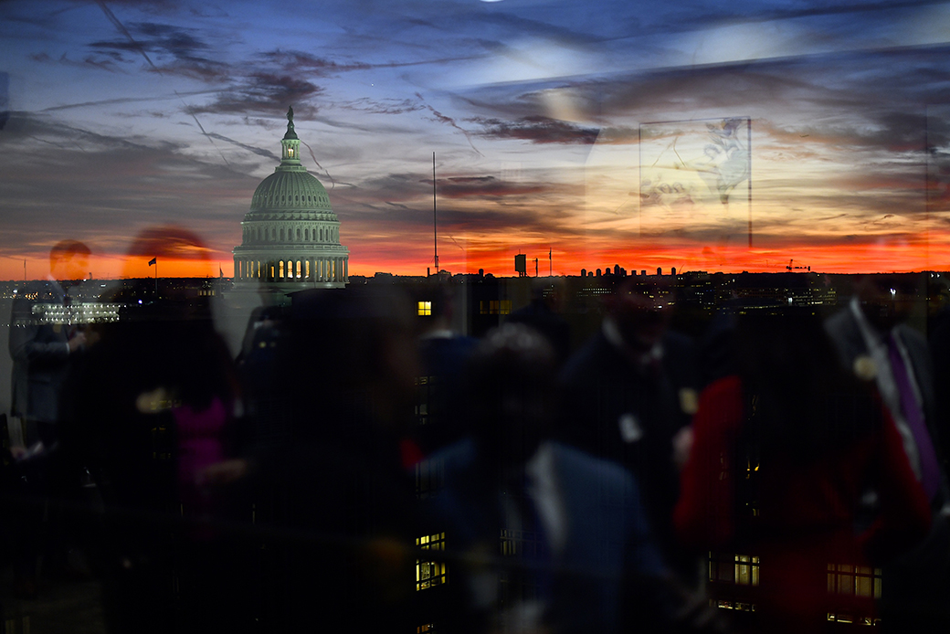 Congressional staff are reflected as the sun sets behind the U.S. Capitol Building on November 13, 2019, in Washington, D.C. (Sun sets behind the Capitol)